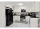 Modern kitchen featuring white cabinets, black countertops, and stainless steel appliances at 148 Linwood Dr, Albemarle, NC 28001