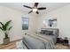Bright bedroom with large window, ceiling fan, gray bedding and wood-look flooring at 1498 Oakridge Farm Hwy, Mooresville, NC 28115