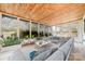 This sunroom boasts floor to ceiling windows, vaulted ceilings, and comfortable furniture at 1498 Oakridge Farm Hwy, Mooresville, NC 28115