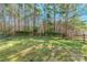 Large grassy backyard with a wooden fence and mature trees at 1515 Kingdom Way, Indian Land, SC 29707