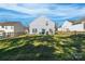 Spacious backyard with lush green grass, wooden fence, and a view of neighboring houses under a bright sky at 1515 Kingdom Way, Indian Land, SC 29707