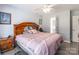 Bedroom with a wooden headboard, side table, and pink bedspread near an open bathroom doorway at 1515 Kingdom Way, Indian Land, SC 29707