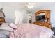 Bedroom showcasing a wooden dresser with mirror and pink bedding with plenty of natural light at 1515 Kingdom Way, Indian Land, SC 29707