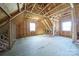 Unfinished attic features exposed wooden beams, windows, and plywood flooring at 175 Riley'S Dr, Salisbury, NC 28146