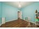 Bright bedroom featuring hardwood floors, blue walls, chandelier, and a white cabinet at 175 Riley'S Dr, Salisbury, NC 28146