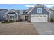 Charming home featuring a stone and siding facade, attached two-car garage, and well-manicured lawn at 1809 Tranquility Blvd, Lancaster, SC 29720