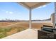 Cozy covered back porch with woven chairs overlooking a vast field and a neighborhood at 1949 Vanderlyn St, Monroe, NC 28112