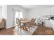 Bright dining area with wood floors, a modern table, and a bar cart adjacent to a window at 1949 Vanderlyn St, Monroe, NC 28112