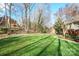 Expansive backyard featuring a lush lawn, mature trees, and a charming wooden fence at 201 Oak Creek Dr, Charlotte, NC 28270