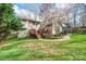 View of the home's backyard featuring a wooden deck, lush lawn, and mature landscaping at 201 Oak Creek Dr, Charlotte, NC 28270