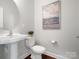 Clean powder room featuring a pedestal sink, toilet, and decorative artwork at 2018 Kensley Dr, Waxhaw, NC 28173