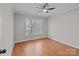 An empty bedroom with ceiling fan, a large window, and wood floors at 2024 Hedgelawn Dr, Charlotte, NC 28262