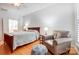 Well-lit bedroom with wood floors, a comfortable chair, and access to other rooms at 2036 Hudson Ln, Fort Mill, SC 29707