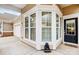 Tan home corner showcasing windows, a doorway, and a glimpse of the garage and outdoor decor at 2036 Hudson Ln, Fort Mill, SC 29707