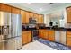Open kitchen featuring stainless steel appliances, wooden cabinets, and a view into the dining area at 2036 Hudson Ln, Fort Mill, SC 29707