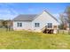 Home back exterior showcases a well-kept lawn, classic siding, a small deck, and a fenced yard at 2504 Hovis Rd, Lincolnton, NC 28092