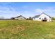 Home's backyard featuring lawn, fence, deck, and other houses nearby at 2504 Hovis Rd, Lincolnton, NC 28092