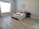 Bright bedroom with wood floors, a large window, and a cozy bed setup at 2504 Hovis Rd, Lincolnton, NC 28092