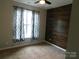 Bedroom featuring modern accent wall, ceiling fan, large window, and carpeted floors at 2504 Hovis Rd, Lincolnton, NC 28092