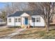 Charming exterior view showcasing the home's white siding, blue door, and landscaped front yard at 312 Motz Ave, Lincolnton, NC 28092