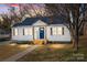 Charming home featuring a blue metal roof, wood accents, and a welcoming blue front door at 312 Motz Ave, Lincolnton, NC 28092