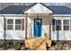 Close up of the entrance with a bright blue door and 'WELCOME' sign adds to this cozy home's curb appeal at 312 Motz Ave, Lincolnton, NC 28092