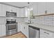 Modern kitchen featuring stainless steel appliances, white cabinets, and stylish subway tile backsplash at 312 Motz Ave, Lincolnton, NC 28092