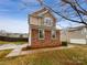 Two-story home featuring stone accents, tidy landscaping, and a paved driveway leading to the garage at 352 Anvil Draw Pl, Rock Hill, SC 29730