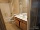 Bathroom with a shower-tub, and a vanity with storage beneath, showing signs of wear and needing updating at 5315 Airport Dr, Charlotte, NC 28208