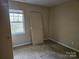 Small bedroom with a window and a door, awaiting a new tenant to revitalize the space at 5315 Airport Dr, Charlotte, NC 28208