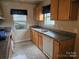 Outdated kitchen featuring wooden cabinets, a double basin sink, and a window for natural light at 5315 Airport Dr, Charlotte, NC 28208
