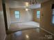 Spacious living room with visible wear and tear, featuring two windows and a ceiling fan at 5315 Airport Dr, Charlotte, NC 28208