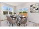 Dining area featuring a modern glass table, six chairs, a sliding glass door, and natural light at 6117 Grove Park Blvd, Charlotte, NC 28215
