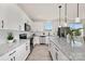 Bright kitchen features white cabinets, granite countertops, stainless appliances, and an island at 6117 Grove Park Blvd, Charlotte, NC 28215