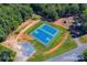 Aerial view of community basketball and tennis courts surrounded by lush greenery at 630 Pinelake Dr, Troy, NC 27371