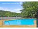 Refreshing community pool surrounded by lush greenery and a tranquil lake view at 630 Pinelake Dr, Troy, NC 27371