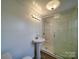 A clean bathroom featuring a pedestal sink and a glass-enclosed shower, perfect for a modern touch at 704 Mill St, Albemarle, NC 28001