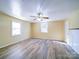 This empty bedroom shows the plank flooring, two windows, and a ceiling fan at 704 Mill St, Albemarle, NC 28001
