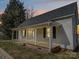 Charming home featuring a welcoming front porch with classic white pillars and black shuttered windows at 704 Mill St, Albemarle, NC 28001