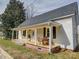 Charming home featuring a welcoming front porch, white pillars, and a dining table with chairs at 704 Mill St, Albemarle, NC 28001