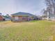 Brick home with spacious backyard, well-maintained lawn, storage shed, and mature trees at 8353 Emily Dr, Harrisburg, NC 28075