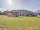 Spacious backyard with brick home, patio, lush green lawn, and privacy fence at 8353 Emily Dr, Harrisburg, NC 28075