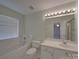 Well-lit bathroom features a combined tub and shower, toilet, and a vanity with sink and a large mirror at 8353 Emily Dr, Harrisburg, NC 28075