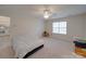 Spacious carpeted bedroom features a ceiling fan, natural light from the window, and neutral-colored walls at 8353 Emily Dr, Harrisburg, NC 28075