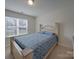 Comfortable bedroom featuring light-colored wood trim, a large bed, and a sunny window creating a relaxing ambiance at 8353 Emily Dr, Harrisburg, NC 28075