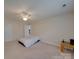 Spacious carpeted bedroom features a ceiling fan, natural light from the window, and neutral-colored walls at 8353 Emily Dr, Harrisburg, NC 28075