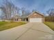 Charming brick home featuring an attached two-car garage and a well-manicured front lawn with driveway at 8353 Emily Dr, Harrisburg, NC 28075
