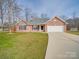 Charming brick home with a two-car garage and a well-manicured lawn, offering curb appeal and convenience at 8353 Emily Dr, Harrisburg, NC 28075