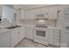 Bright kitchen featuring white appliances and cabinets, providing a clean and functional cooking space at 8353 Emily Dr, Harrisburg, NC 28075