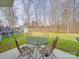 A backyard patio with outdoor seating, a green table, a lush lawn, and a storage shed in the background at 8353 Emily Dr, Harrisburg, NC 28075